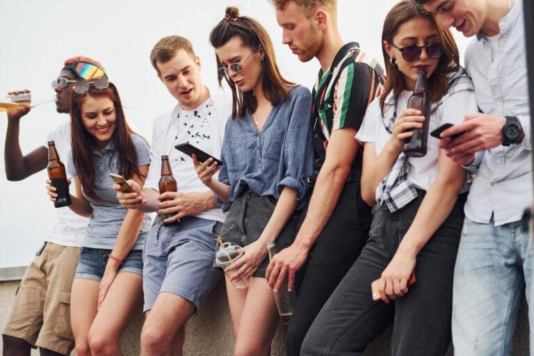 standing with phones alcohol hands group young people casual clothes have party rooftop together daytime