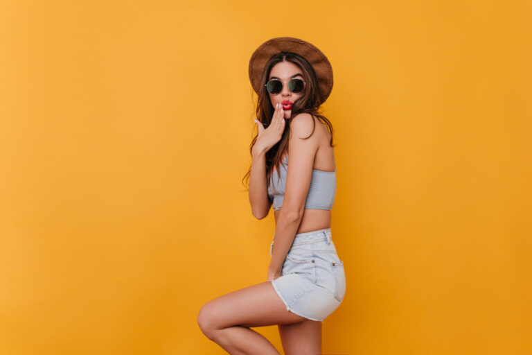 refined shapely girl wears blue denim shorts playfully posing